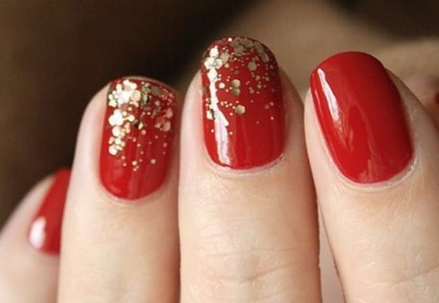 Des ongles rouges avec des paillettes dorées