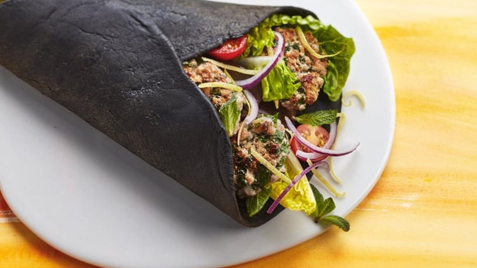Pita à l’encre de seiche, haché de veau, aubergine grillée et bergamote