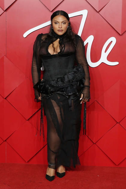 Paloma Elsesser en robe transparente noire à volants Dilara et escarpins Jimmy Choo