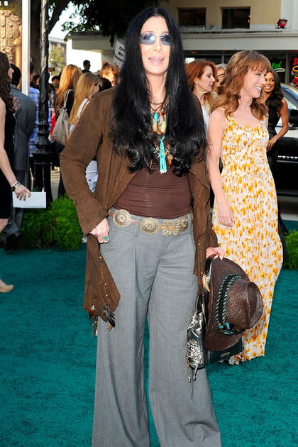 Cher en veste en daim marron, pantalon fluide et chapeau