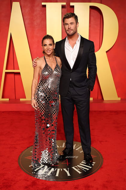 Elsa Pataky en robe à disques argentés Rabanne et Chris Hemsworth en costume noir