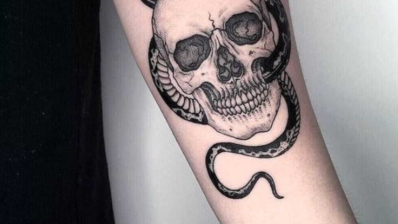 Tête de mort et serpent sur l'avant-bras