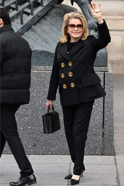 Catherine Deneuve en pantalon noir et veste à double boutonnage