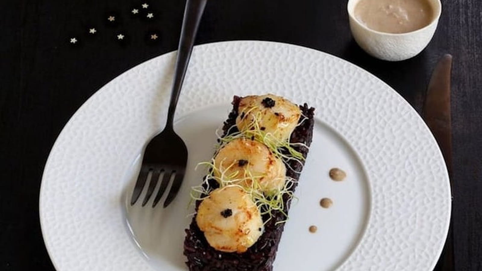 Riz vénéré aux noix de Saint-Jacques et graines germées, sauce au confit d'ail noir