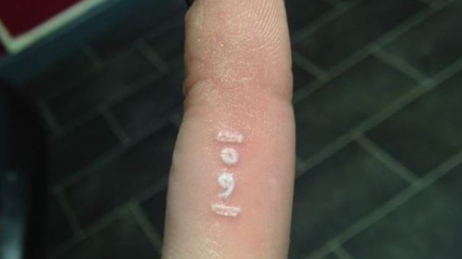 Point-virgule à l'encre blanche sur le doigt