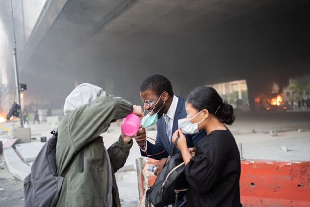 Un manifestant verse du lait sur le visage de personnes aveugl&eacute;s par les gazs lacrymog&egrave;nes