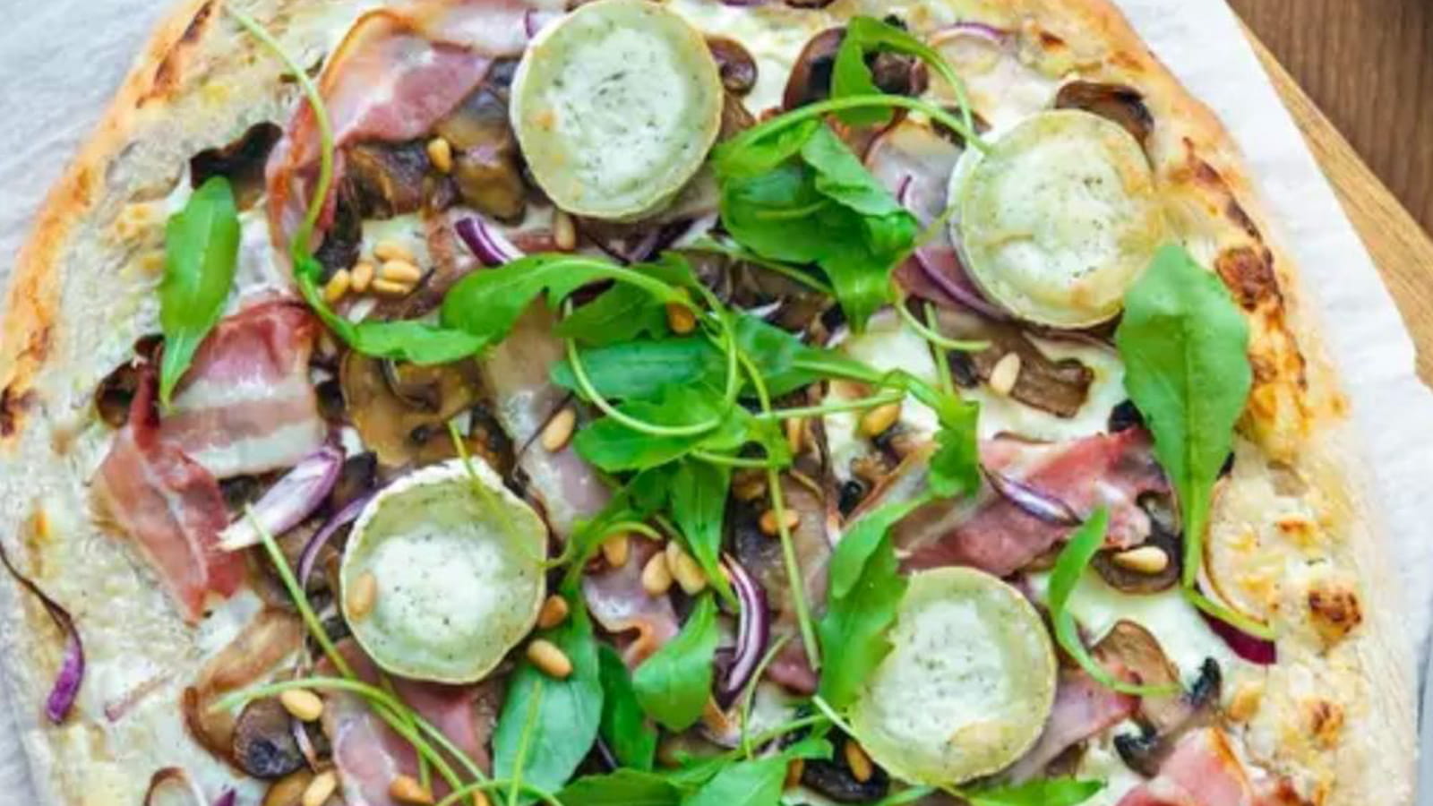Pizza chèvre, poitrine fumée, champignons et roquette