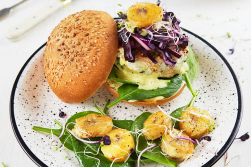 Burger de poulet, sauce banane curry, bananes rôties et pousses d’épinard
