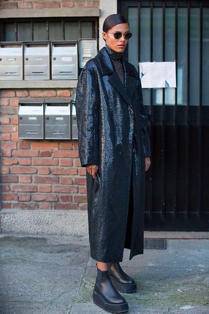 Tina Kunakey en manteau noir à sequins et bottines à plateforme