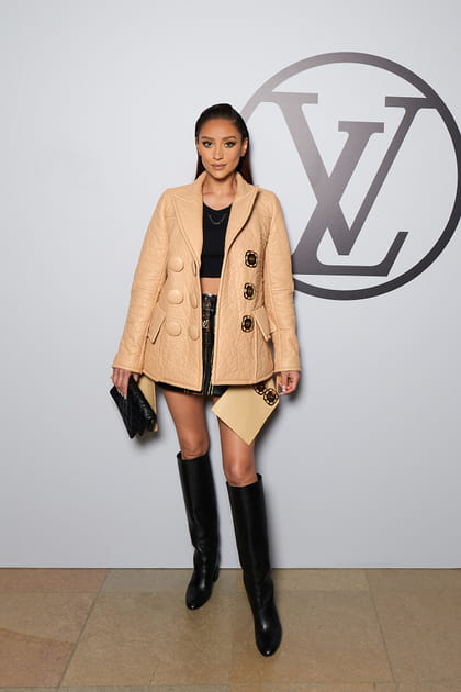Shay Mitchell en veste beige matelassée à boutons et minijupe noire au défilé Louis Vuitton