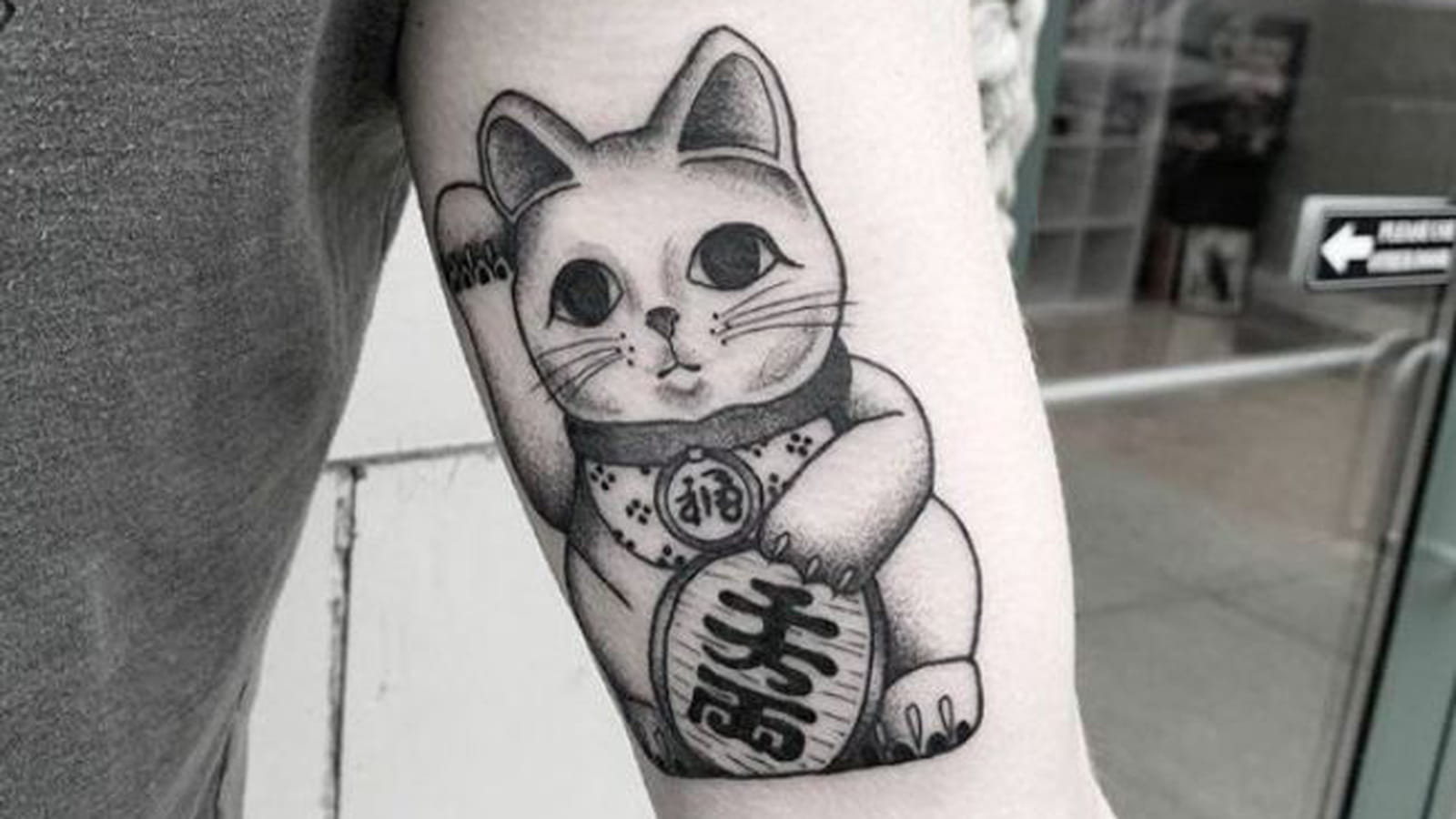 Chat porte-bonheur japonais sur le bras