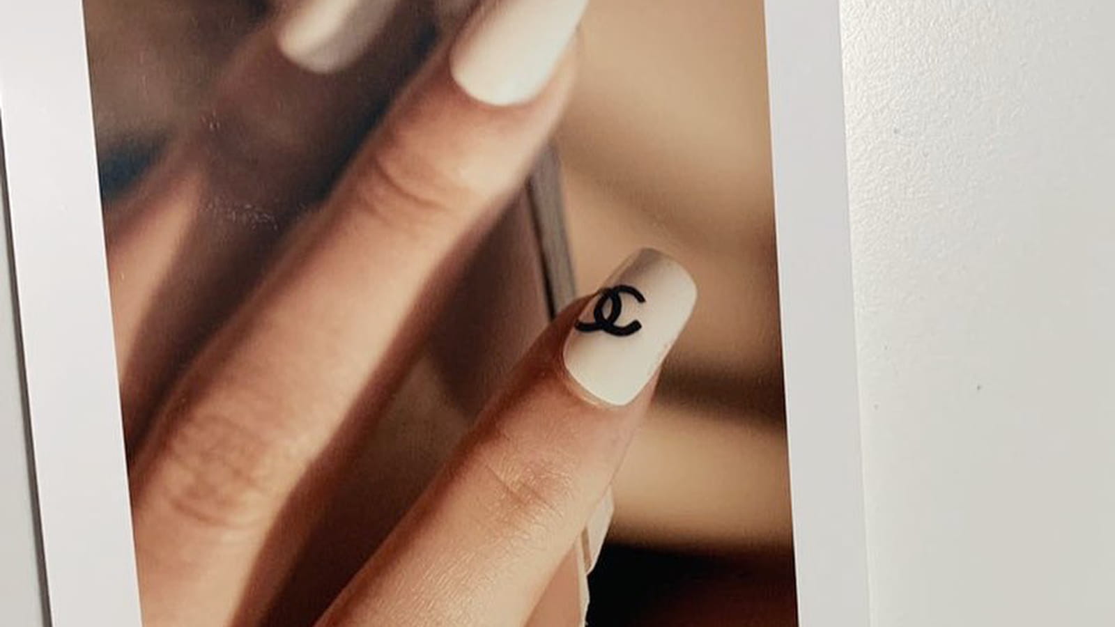Une manucure nude avec un logo