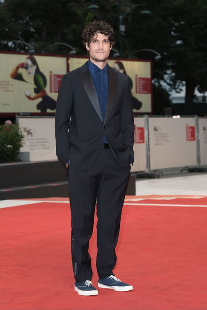 Louis Garrel en costume noir et chemise bleu marine