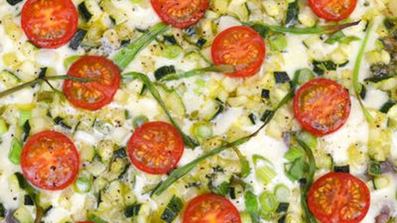 Pizza de courgette, jambon cru, tomates cerise, pesto et mozzarella