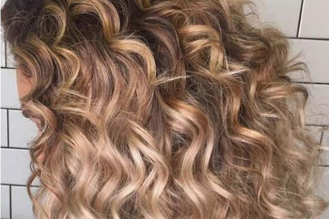 Balayage blond sur cheveux bouclés