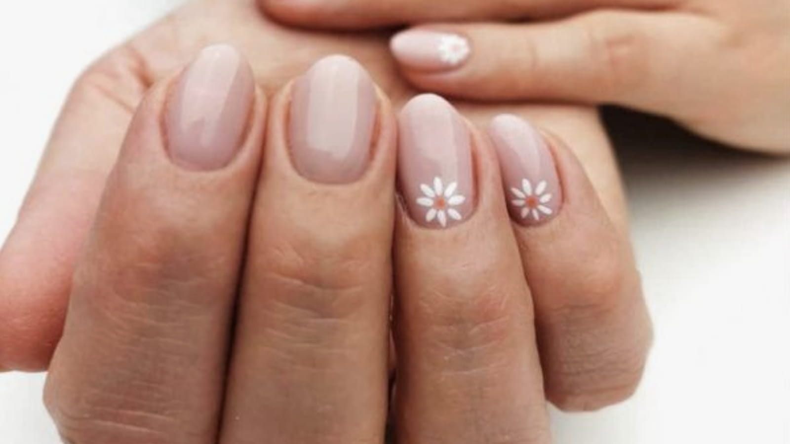 Une manucure nude avec des fleurs