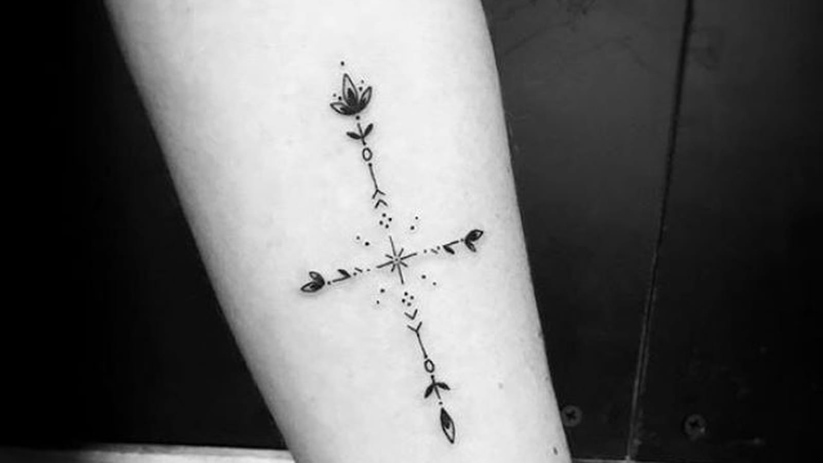 Croix et fleur de lotus sur l'avant-bras