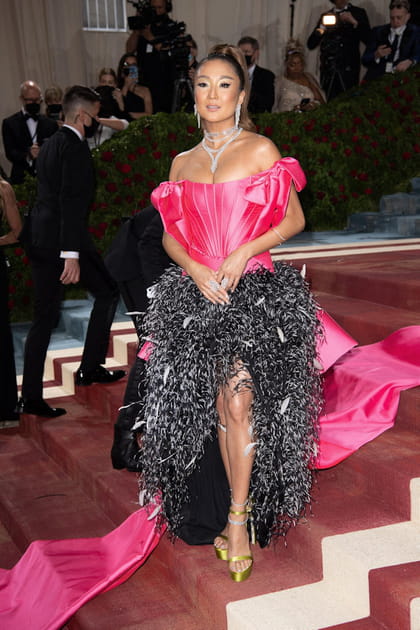 Ashley Park en robe rose et noir &agrave; rubans et &agrave; plumes