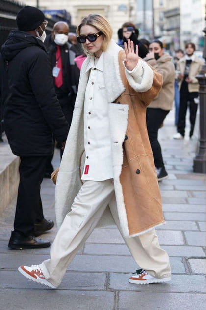Gigi Hadid en pantalon crème et manteau en peau retournée