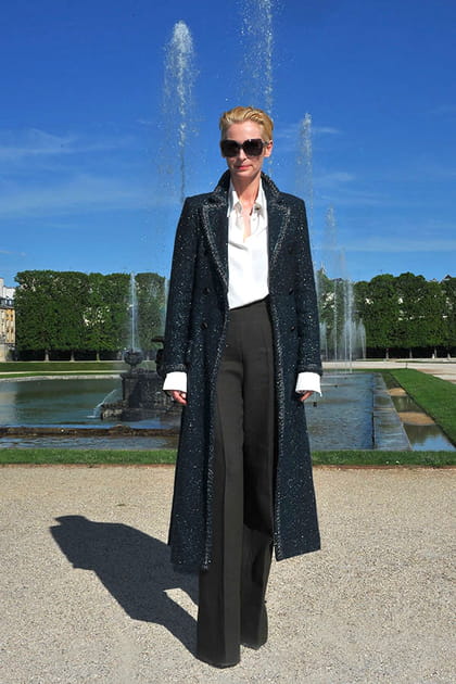 Tilda Swinton en chemise blanche, pantalon noir et manteau long