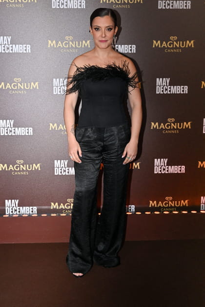 Camille Lellouche en top bustier noir à plumes et pantalon en soie