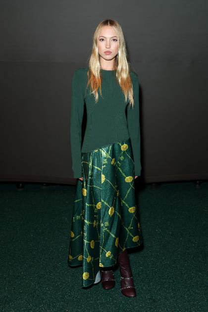 Lila Moss en pull vert et jupe satin&eacute;e &agrave; motifs