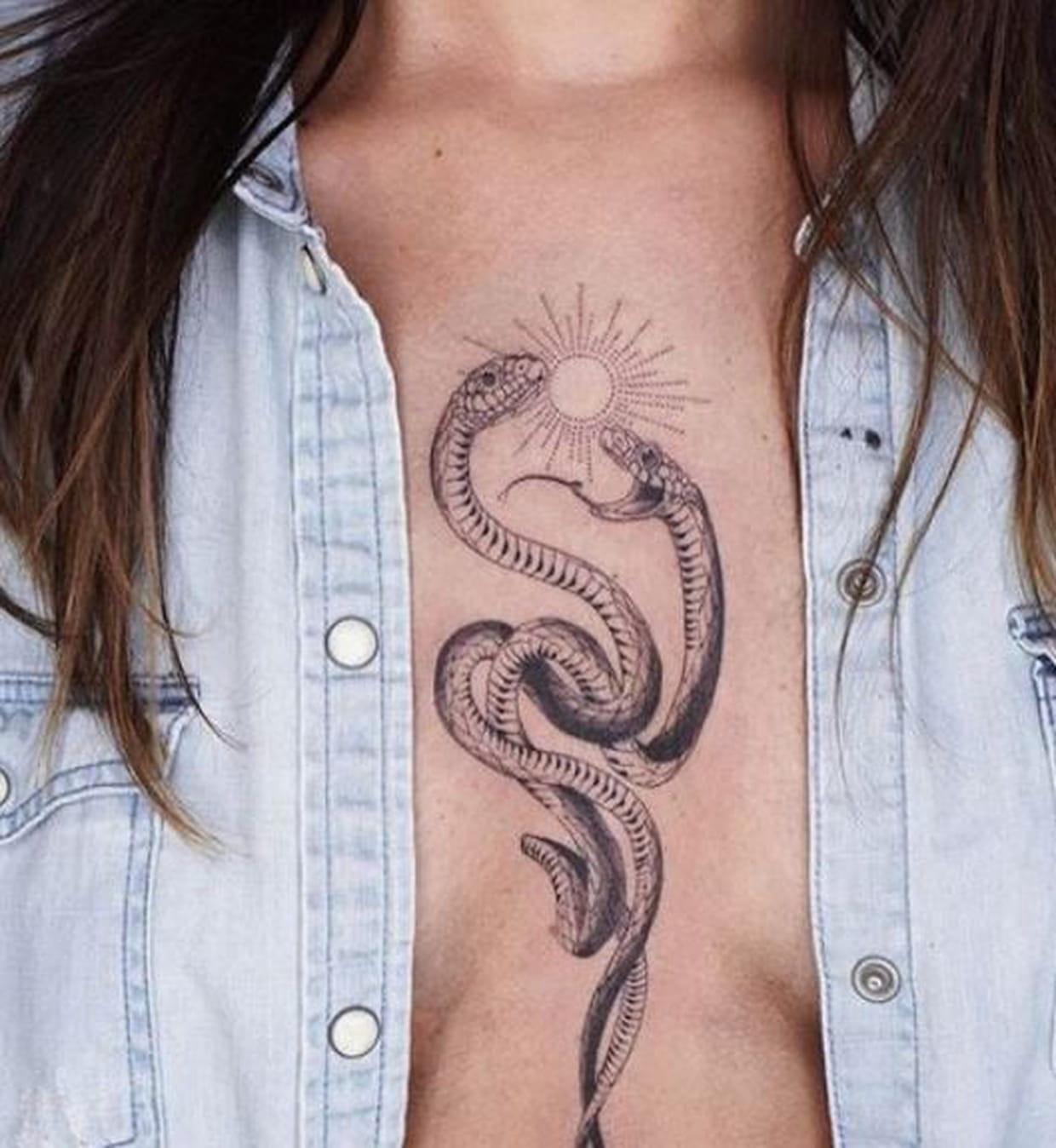 Tatouage Serpent Entre Les Seins Serpents et soleil au centre de la poitrine