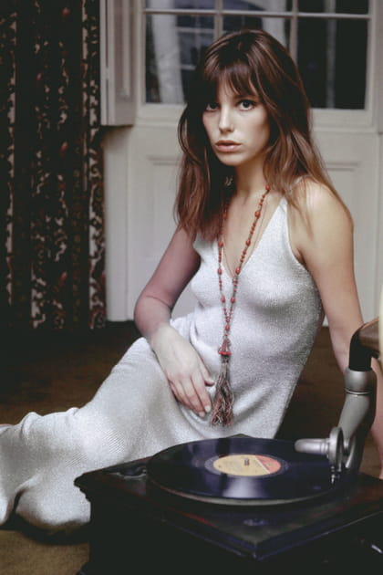 Jane Birkin en longue robe blanche et sautoir orange