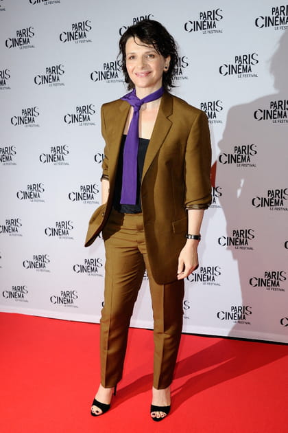 Juliette Binoche en costume brun et cravate violette
