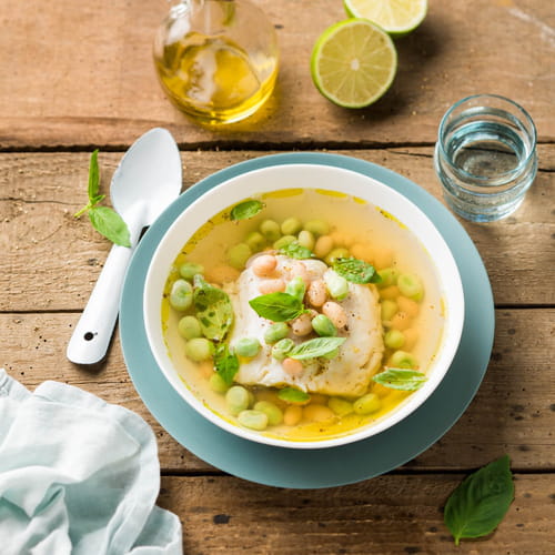 Filet de Merlu servi dans un bouillon de volaille au citron vert, haricots blancs, fèves et basilic frais