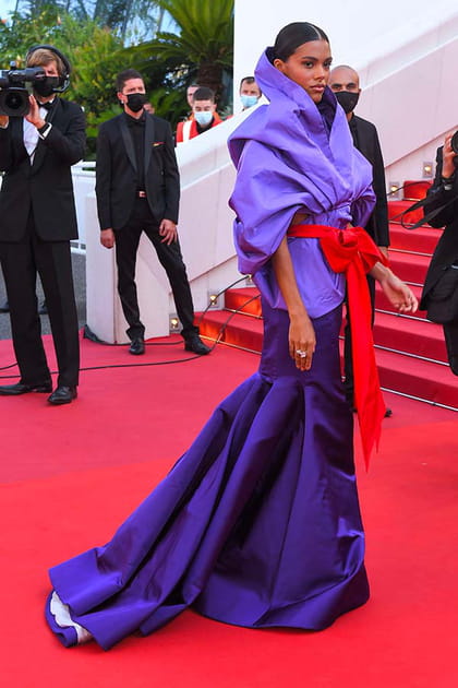 Tina Kunakey en robe violette évasée et ceinture longue rouge Valentino