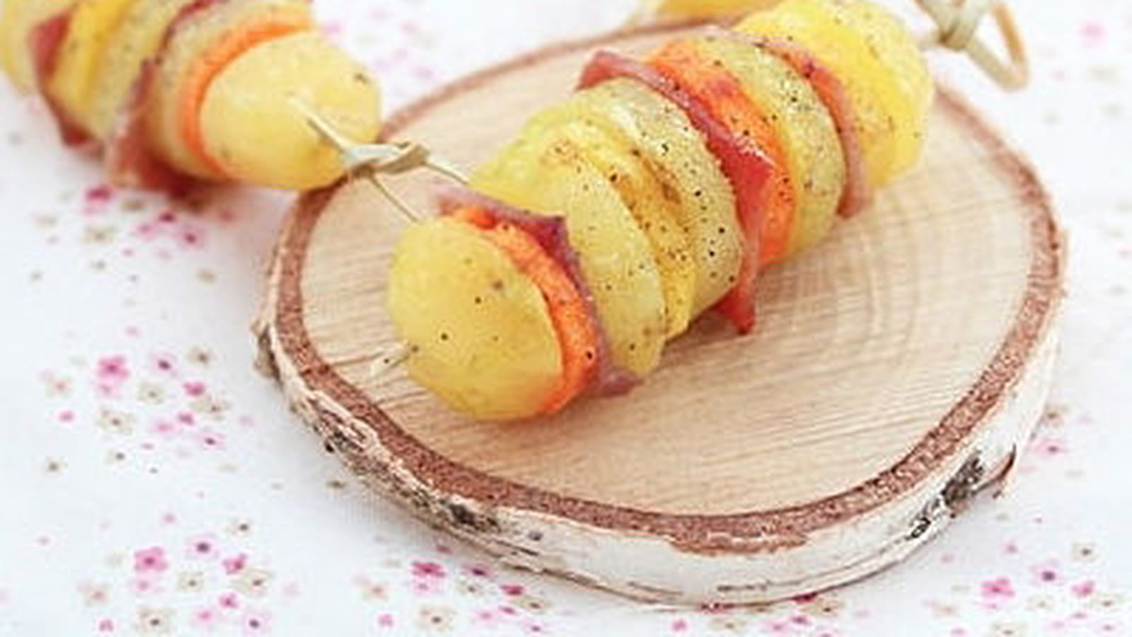 Brochettes de pommes de terre, carottes oranges et jaunes, jambon cru