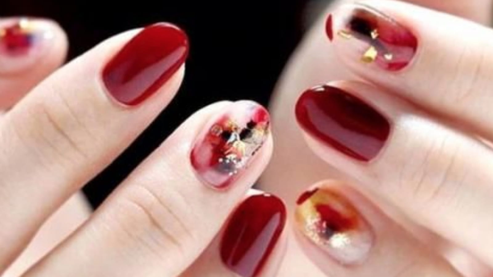 Des ongles rouges avec un nail art abstrait