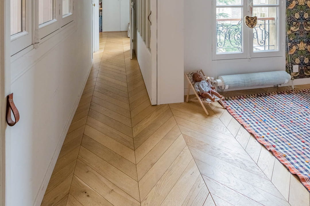 Un couloir mis en valeur par un beau parquet en point de Hongrie