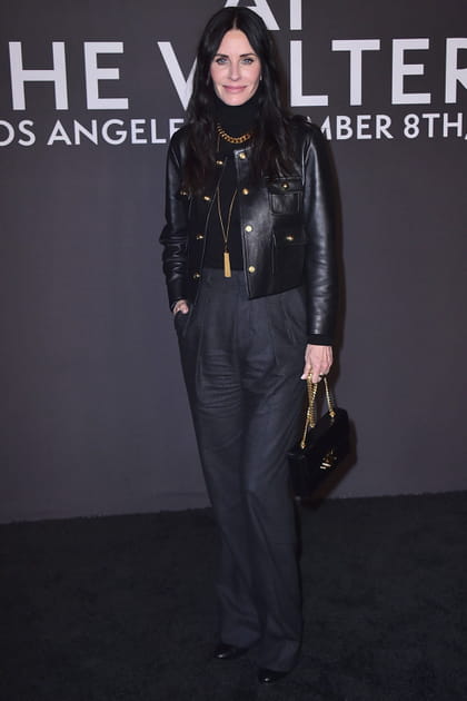 Courteney Cox en veste courte en cuir noir et pantalon à pinces