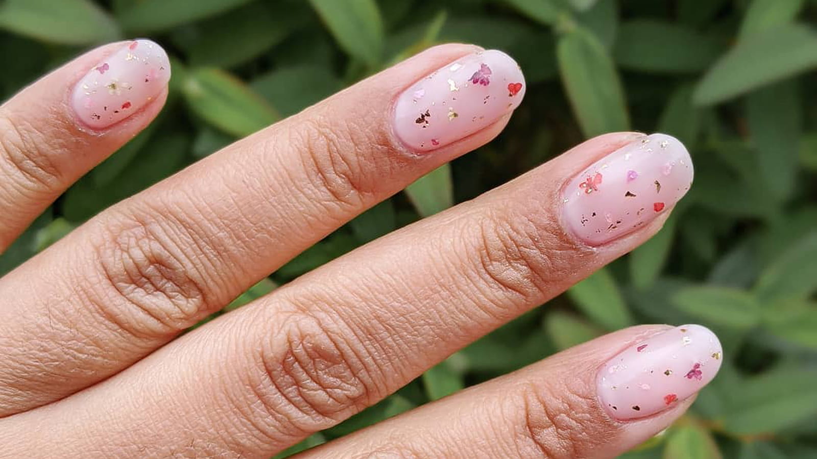 Une manucure à fleurs et paillettes discrètes