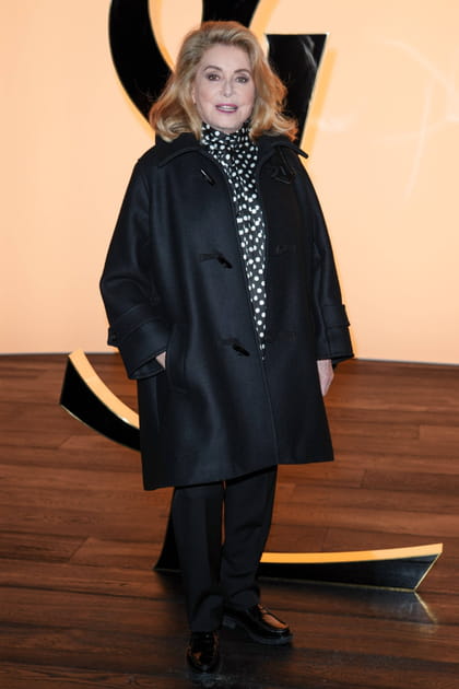 Catherine Deneuve en manteau satiné et blouse imprimée