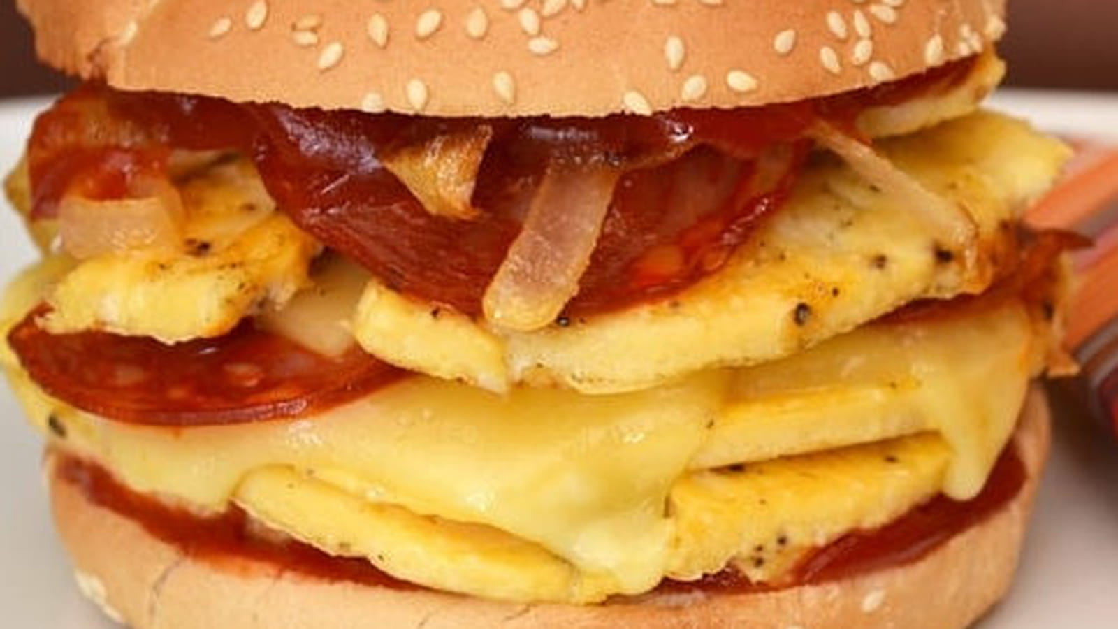 Burger à l'omelette, oignons, chorizo et fromage à raclette