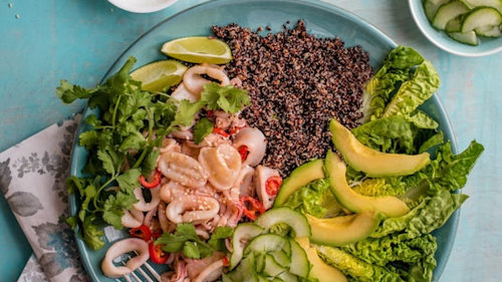 Salade de calamar à l’ail et au chili accompagnée de concombre, avocat et quinoa
