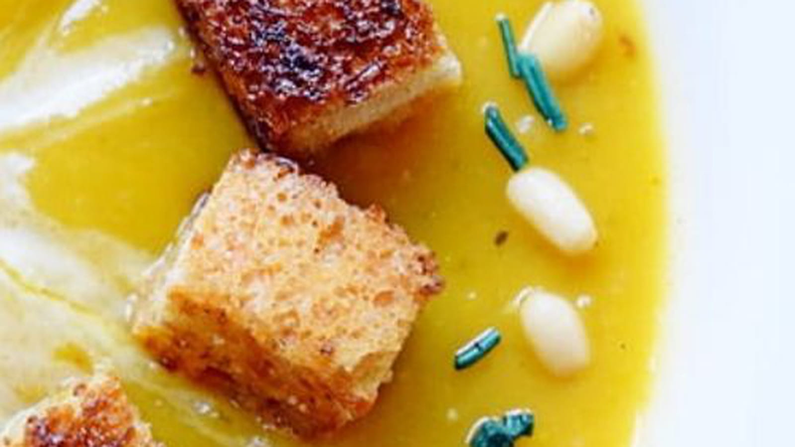 Potage au butternut et carottes garni de croûtons, pignons et spiruline