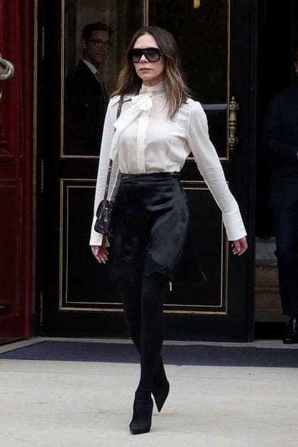 Victoria Beckham en blouse blanche à col lavallière et jupe satinée noire