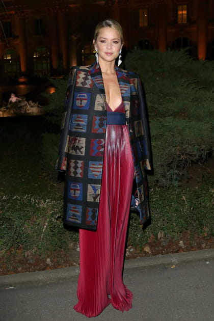 Virginie Efira en robe plissée rouge irisée et manteau mi-long imprimé