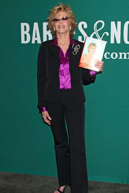 Jane Fonda en tailleur pantalon noir et blouse violette