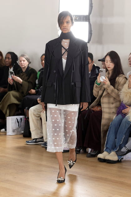 Veste &agrave; franges noire et robe blanche &agrave; plumetis&nbsp;aper&ccedil;ues sur le d&eacute;fil&eacute; Eudon Choi