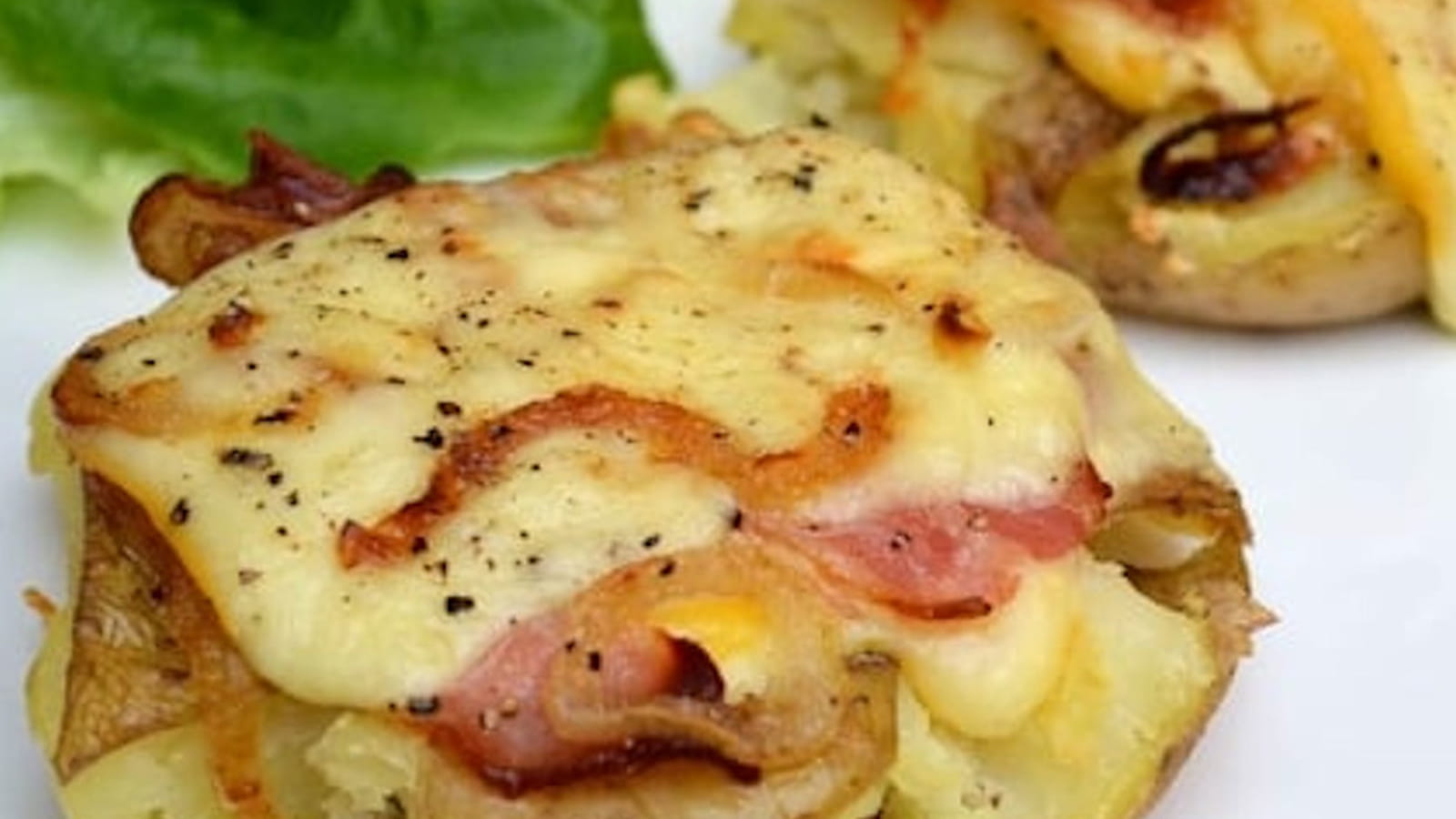 Pommes de terre au fromage à raclette, lard fumé et oignons grillés