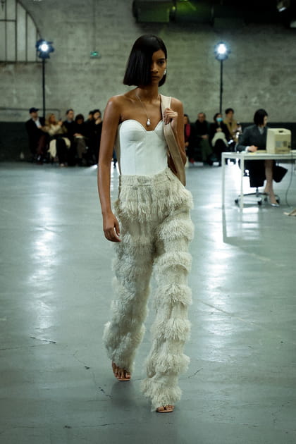 Bustier blanc et pantalon à franges aperçus sur le défilé Rokh