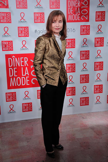 Isabelle Huppert en pantalon noir et veste dorée