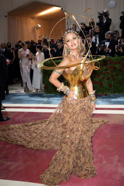 Natasha Poonawalla dans une robe dor&eacute;e avec structure m&eacute;tallique