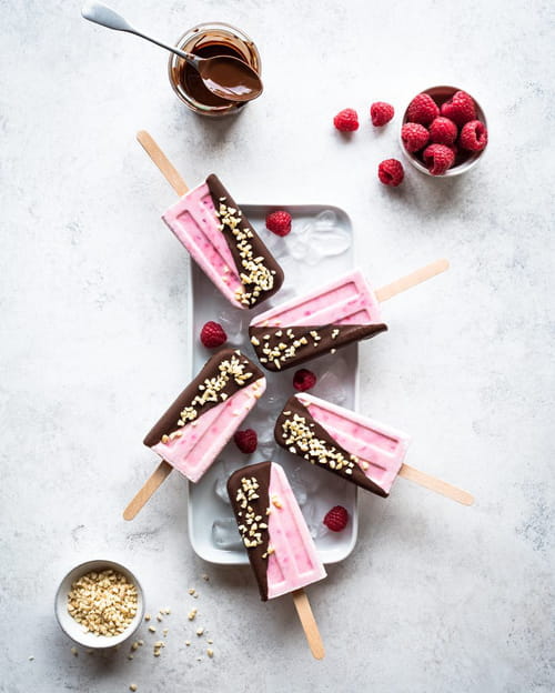 Bâtonnets glacés framboise noix de coco, enrobés de chocolat noir Cémoi