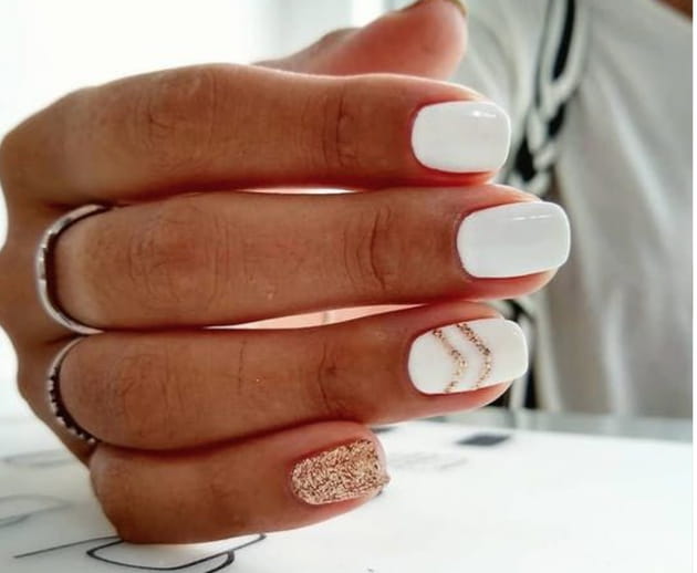 Des ongles blancs avec des détails dorés